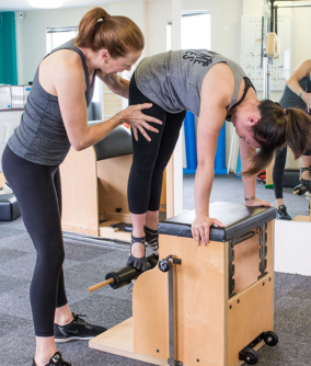 two ladies doing pilates on a wunda chair